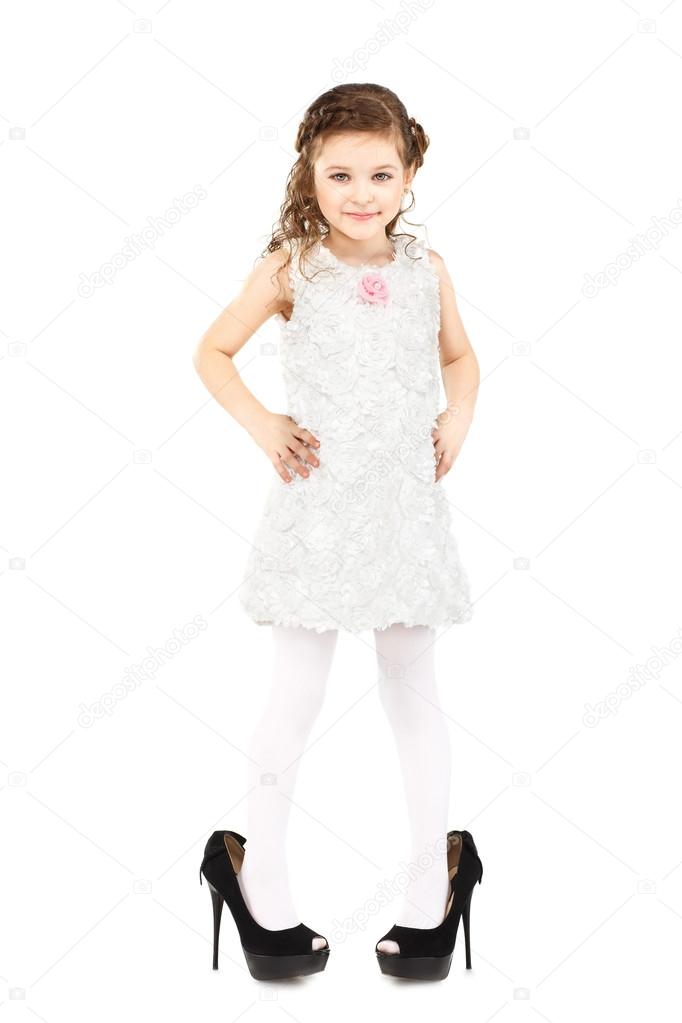 Little girl dressed great mother's shoes isolated on white backg