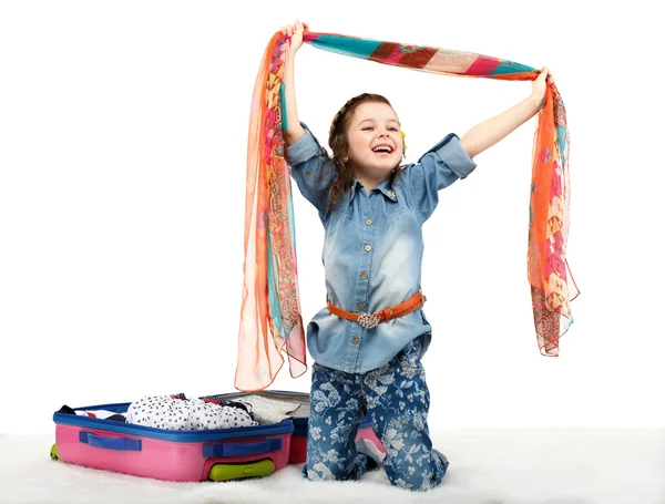 Fashionable little girl unpacking a suitcase — Stock Photo, Image