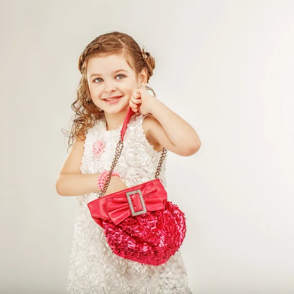 Маленька дівчинка тримає рожеву сумку — стокове фото