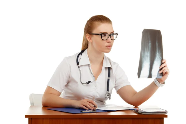 Young beautiful woman doctor inspects an X-ray of the foot — Stock Photo, Image