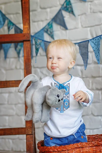 Retrato de um menino engraçado com um gatinho de brinquedo — Fotografia de Stock