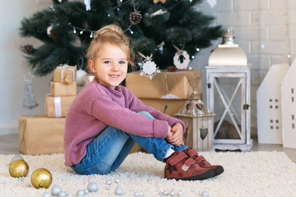 Niña esperando un milagro en las decoraciones navideñas — Foto de Stock