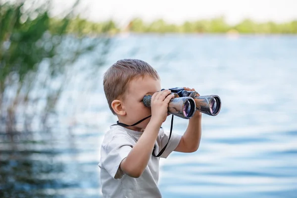 Menino olhando através de binóculos — Fotografia de Stock