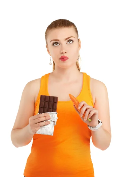 Portrait of a pretty girl having a dilemma with her diet. Isolat — Stock Photo, Image