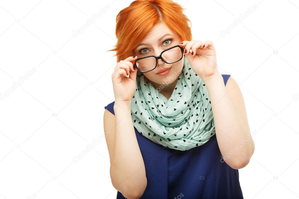 Portrait of surprised red-haired young woman holding glasses on 