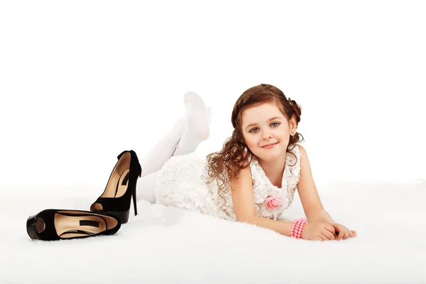 Porträtt av en söt liten rolig mode flicka liggande på en fluffig r — Stockfoto