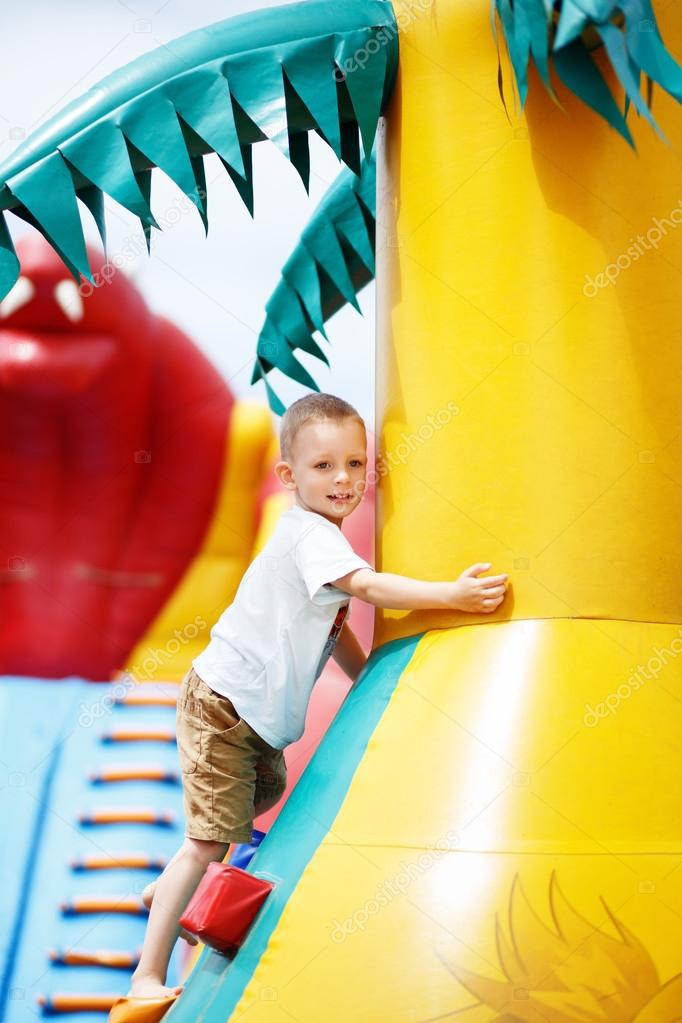 Little cool boy have fun on an inflatable trampoline