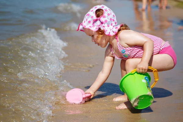 छोटी लड़की समुद्र तट पर खेल रही — स्टॉक फ़ोटो, इमेज