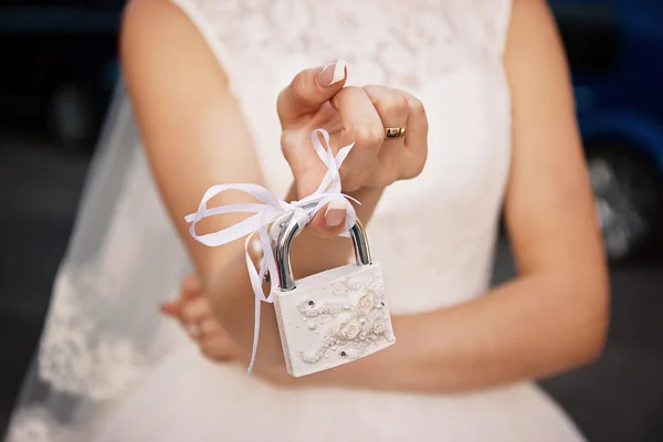 La novia sostiene un candado blanco cerrado . — Foto de Stock