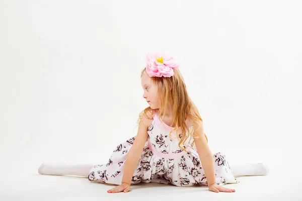 Kleines blondes Mädchen in einem Kleid, das auf dem Bindfaden sitzt — Stockfoto