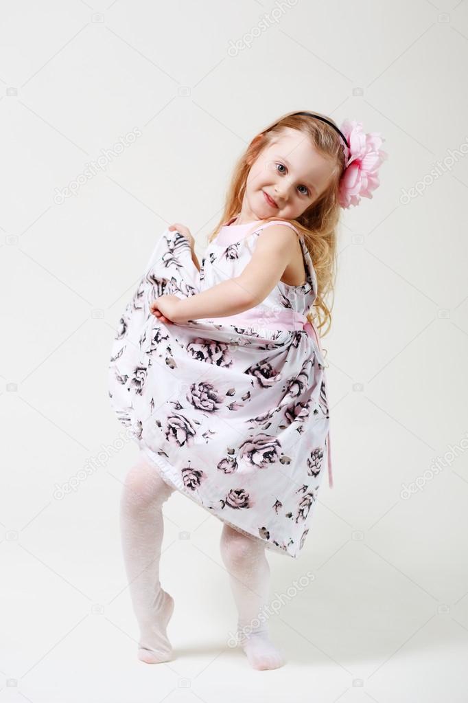 Full length portrait of a cute little blonde girl dancing