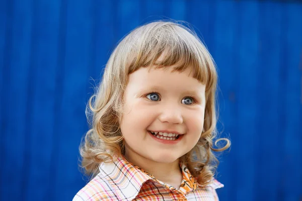 Ritratto di felice gioiosa bella bambina contro il blu — Foto Stock