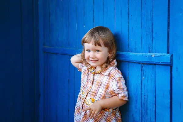 青い壁に幸せな笑顔のかわいい少女の肖像画 — ストック写真