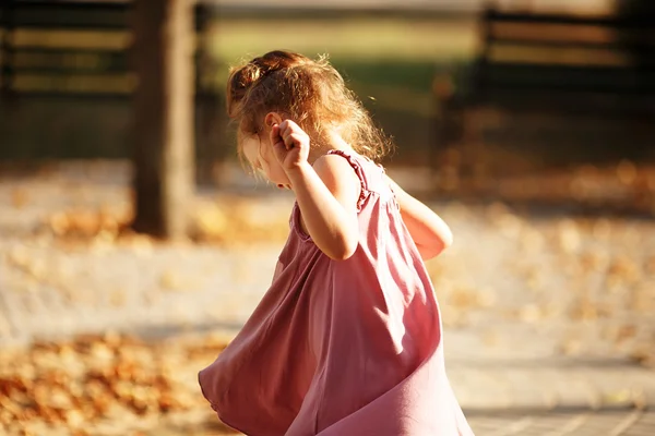 Retrato de una niña bailando en el parque un otoño cálido incluso — Foto de Stock