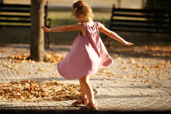Ganzkörperporträt eines kleinen Mädchens, das im Park ein warmes — Stockfoto
