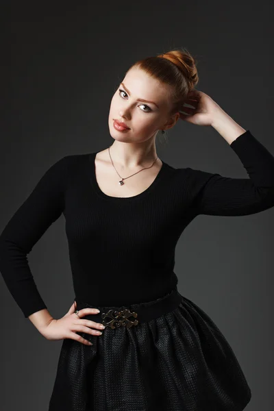 Portrait of a young beautiful girl in black clothing on a gray b — Stock Photo, Image