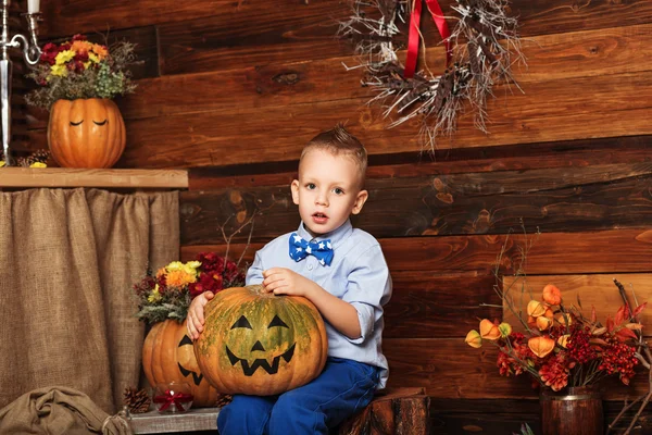 Halloween party with child holding painted pumpkin — Stock Photo, Image