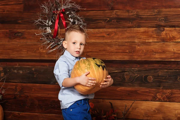 Halloween party with child holding painted pumpkin — Stock Photo, Image