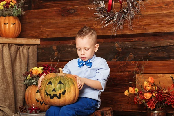 Halloween party with child holding painted pumpkin — Stock Photo, Image