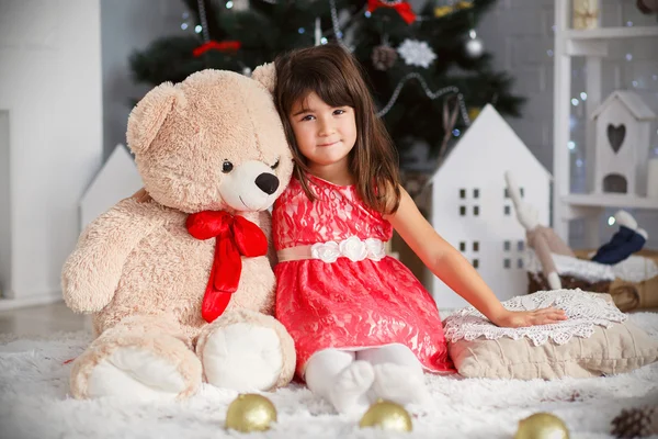 Retrato de uma menina morena bonito abraçando um grande ursinho de pelúcia — Fotografia de Stock