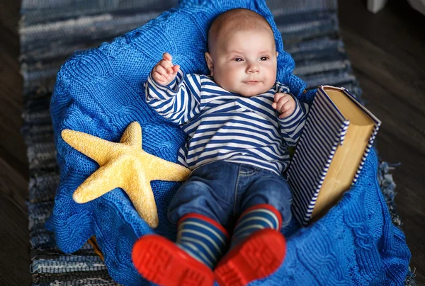 Retrato de um menino bonito em um colete listrado e botas — Fotografia de Stock