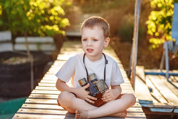 Chłopczyk patrząc przez lornetka kamuflażu na brzegu rzeki — Zdjęcie stockowe