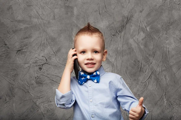 Retrato de un lindo niño en camisa azul y pajarita con multitud —  Fotos de Stock