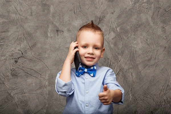 Portrait of a cute little boy in blue shirt and bow tie with mob — Stock Photo, Image