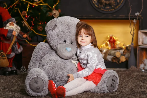 Retrato de una linda niña abrazando a un oso de peluche gris suave — Foto de Stock