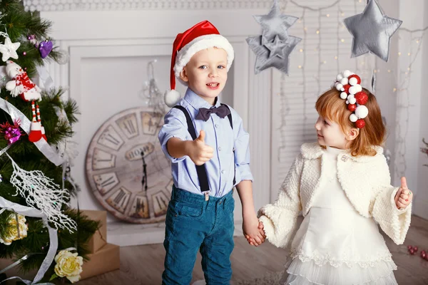 Zwei kleine Kinder amüsieren sich in der Nähe des Weihnachtsbaums. Neues Jahr — Stockfoto