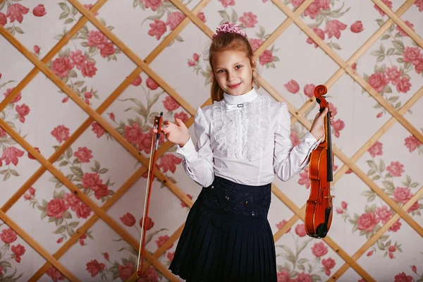 Vacker liten flicka spelar på fiol mot den bakgrund o — Stockfoto