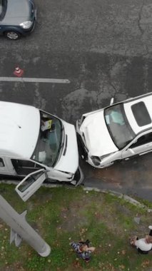 İki beyaz aracın çarpışmasını içeren ciddi bir trafik kazası. İki aracın ön uçları da ezilmiş. İHA görüntüsü. Sigorta, yol güvenliği ve ulaşım.