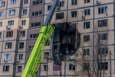 Bir apartman binasının ön cephesinin bir parçası. Patlama ya da bombardıman sonucu oluşan büyük hasarı gösteriyor. Duvardaki gedik birkaç kat boyunca uzanıyor ve yıkılan iç mekanı ortaya çıkarıyor..