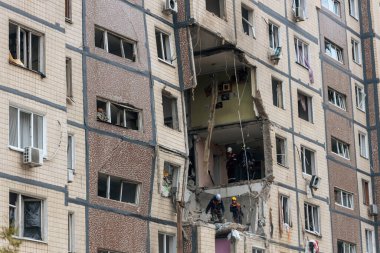 Bir apartman binasının ön cephesinin bir parçası. Patlama ya da bombardıman sonucu oluşan büyük hasarı gösteriyor. Duvardaki gedik birkaç kat boyunca uzanıyor ve yıkılan iç mekanı ortaya çıkarıyor..
