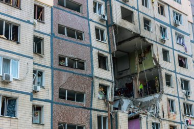 Bir apartman binasının ön cephesinin bir parçası. Patlama ya da bombardıman sonucu oluşan büyük hasarı gösteriyor. Duvardaki gedik birkaç kat boyunca uzanıyor ve yıkılan iç mekanı ortaya çıkarıyor..