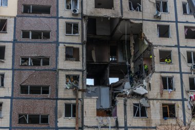 Bir apartman binasının ön cephesinin bir parçası. Patlama ya da bombardıman sonucu oluşan büyük hasarı gösteriyor. Duvardaki gedik birkaç kat boyunca uzanıyor ve yıkılan iç mekanı ortaya çıkarıyor..