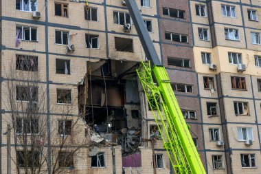 Bir apartman binasının ön cephesinin bir parçası. Patlama ya da bombardıman sonucu oluşan büyük hasarı gösteriyor. Duvardaki gedik birkaç kat boyunca uzanıyor ve yıkılan iç mekanı ortaya çıkarıyor..