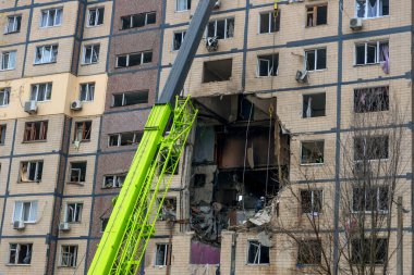 Bir apartman binasının ön cephesinin bir parçası. Patlama ya da bombardıman sonucu oluşan büyük hasarı gösteriyor. Duvardaki gedik birkaç kat boyunca uzanıyor ve yıkılan iç mekanı ortaya çıkarıyor..
