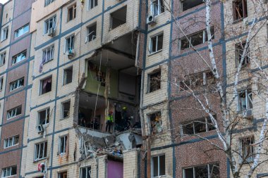 Bir apartman binasının ön cephesinin bir parçası. Patlama ya da bombardıman sonucu oluşan büyük hasarı gösteriyor. Duvardaki gedik birkaç kat boyunca uzanıyor ve yıkılan iç mekanı ortaya çıkarıyor..