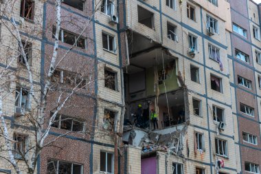 Bir apartman binasının ön cephesinin bir parçası. Patlama ya da bombardıman sonucu oluşan büyük hasarı gösteriyor. Duvardaki gedik birkaç kat boyunca uzanıyor ve yıkılan iç mekanı ortaya çıkarıyor..