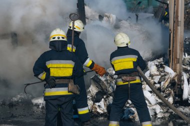 Profesyonel takım çalışması: İtfaiyecilerden oluşan bir ekip, ağır duman altındaki bir yangınla savaşmak için özel ekipman kullanıyor. Bu fotoğraf, takım çalışmalarını ve çabalarını vurguluyor..