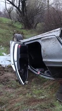 Ciddi bir trafik kazasından sonra çatıya devrildi. Kaza yeri, yıkım ve yol tehlikesi. Kötü havada kontrolü kaybettim..