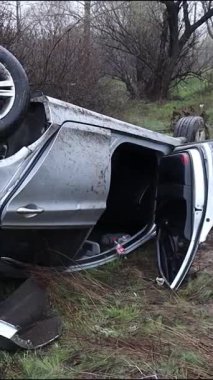 Ciddi bir trafik kazasından sonra çatıya devrildi. Kaza yeri, yıkım ve yol tehlikesi. Kötü havada kontrolü kaybettim..