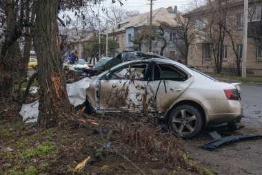 Ciddi bir trafik kazasından sonra bir yolcu arabası büyük hasar gördü. Araba, yolun kenarındaki bir ağaca çarptı. Ön tarafı tamamen tahrip etti. Ön camı kırdı ve yere enkaz ve parçalar saçtı.