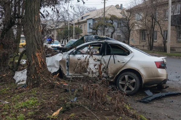 Ciddi bir trafik kazasından sonra bir yolcu arabası büyük hasar gördü. Araba, yolun kenarındaki bir ağaca çarptı. Ön tarafı tamamen tahrip etti. Ön camı kırdı ve yere enkaz ve parçalar saçtı.