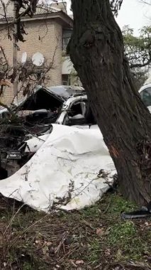 Ciddi bir trafik kazasından sonra beyaz bir yolcu arabası büyük hasar gördü. Araba, yolun kenarındaki bir ağaca çarptı. Ön tarafı tamamen tahrip etti. Ön camı kırdı ve yere enkaz ve parçalar saçtı..