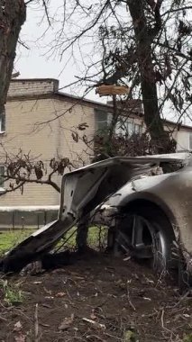 Ciddi bir trafik kazasından sonra beyaz bir yolcu arabası büyük hasar gördü. Araba, yolun kenarındaki bir ağaca çarptı. Ön tarafı tamamen tahrip etti. Ön camı kırdı ve yere enkaz ve parçalar saçtı..