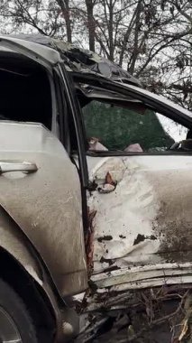 Ciddi bir trafik kazasından sonra beyaz bir yolcu arabası büyük hasar gördü. Araba, yolun kenarındaki bir ağaca çarptı. Ön tarafı tamamen tahrip etti. Ön camı kırdı ve yere enkaz ve parçalar saçtı..