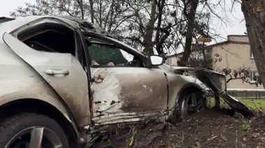 Ciddi bir trafik kazasından sonra beyaz bir yolcu arabası büyük hasar gördü. Araba, yolun kenarındaki bir ağaca çarptı. Ön tarafı tamamen tahrip etti. Ön camı kırdı ve yere enkaz ve parçalar saçtı..