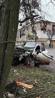 Ciddi bir trafik kazasından sonra beyaz bir yolcu arabası büyük hasar gördü. Araba, yolun kenarındaki bir ağaca çarptı. Ön tarafı tamamen tahrip etti. Ön camı kırdı ve yere enkaz ve parçalar saçtı..